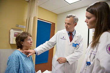 Two physicians looking at a patient's neck