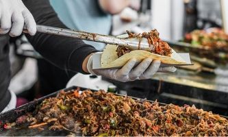 Restaurant worker serving tacos