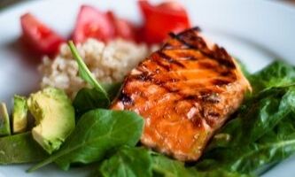 Plate with brown rice, spinach, salmon, and avocado
