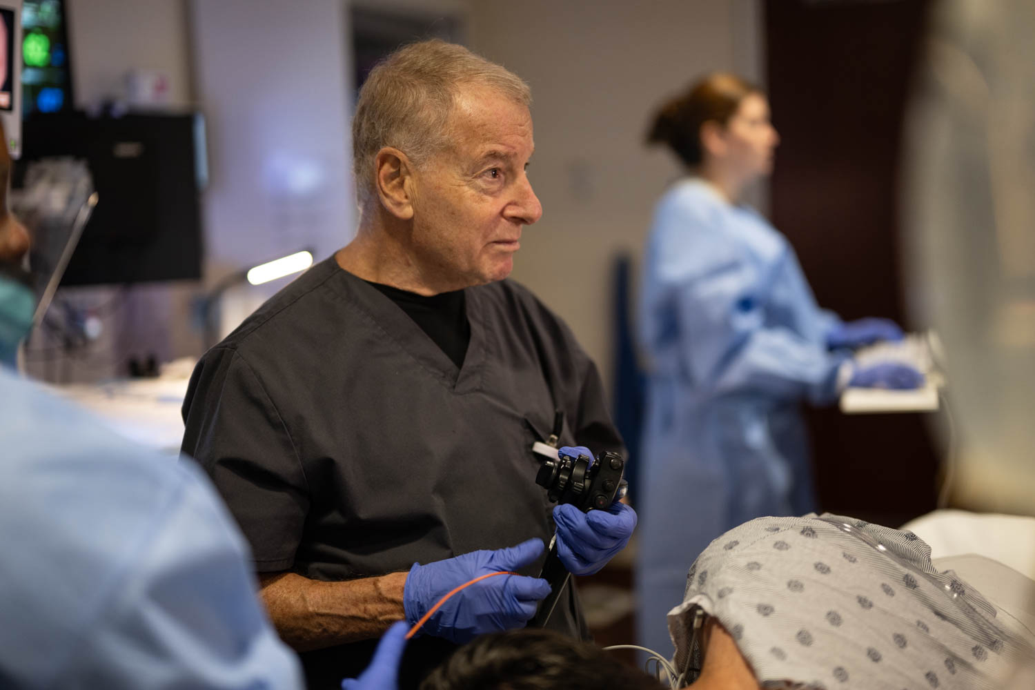 Northwestern Medicine physician holding an endoscope while working with a care team during a procedure in an endoscopy room.