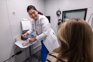 A female audiologist in an audio booth looking at a female patient.