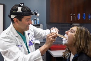 Northwestern Medicine ENT physician Dr. Patel examining a female patient's throat.