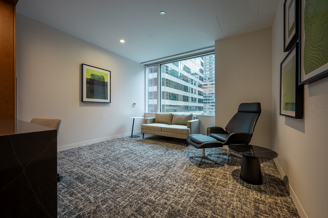A private room with a chair, couch and desk.