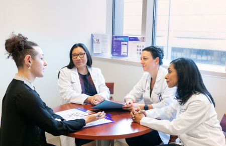 Physicians with the Northwestern Medicine Gender Pathways Program talking with a patient.