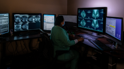 Northwestern Medicine clinical provider sitting in a room filled with computers and looking at patient scans
