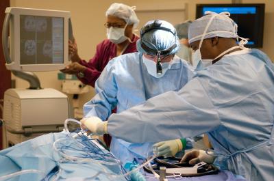 Two physicians operating on a patient