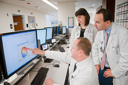 Team of physicians looking at a chart on a computer