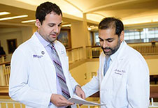 Two Movement Disorders Centers of Excellence physicians reviewing a patient chart.