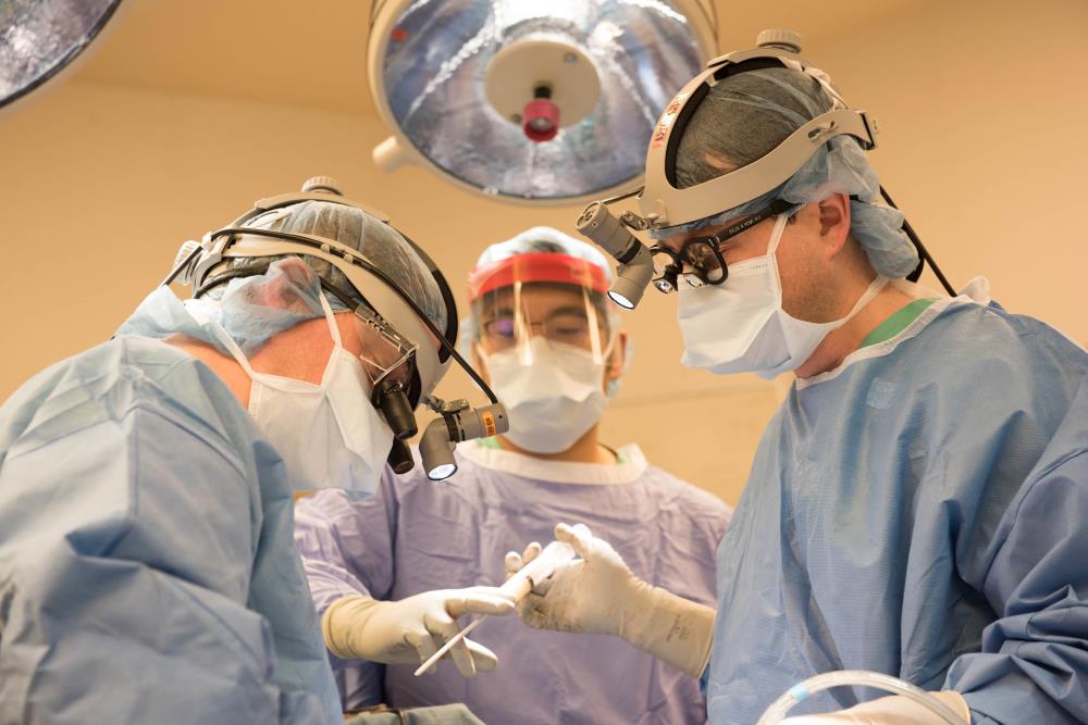 Physicians wearing gowns and masks in an operating room