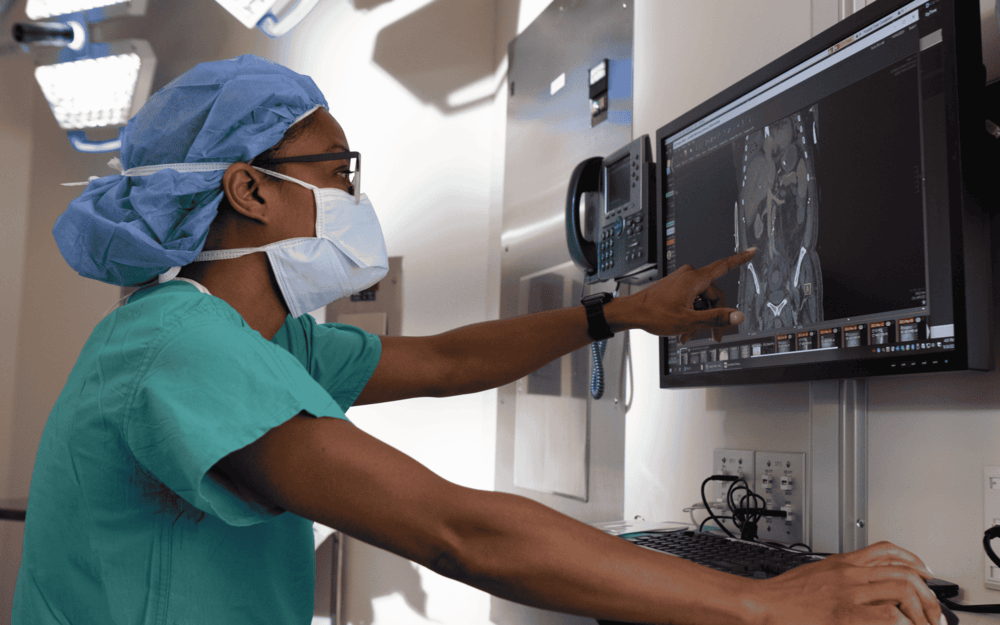 Dr. Simpson pointing at an image on a computer.