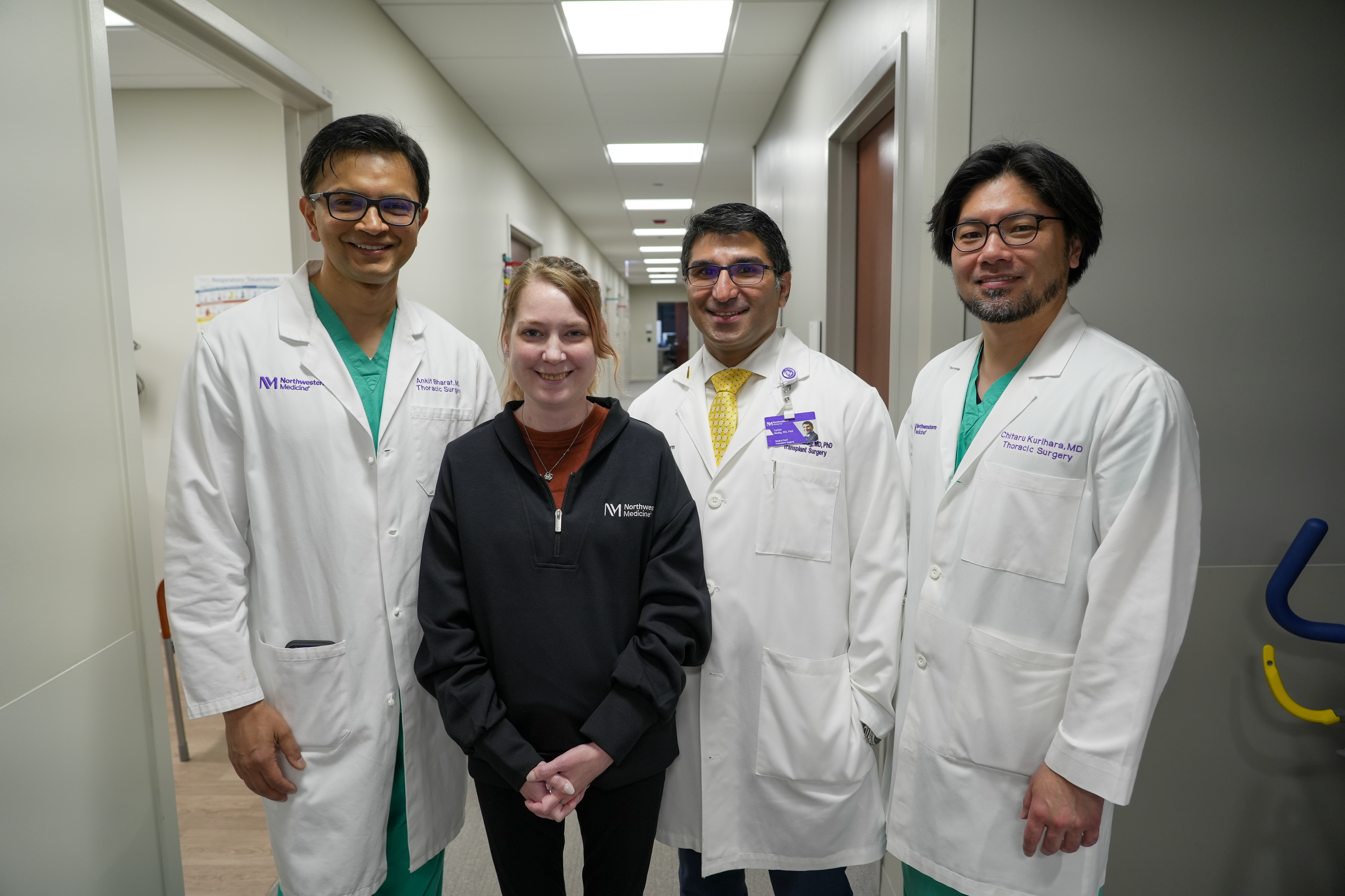 Clinical care team and patient standing together in a Northwestern Medicine outpatient clinic hallway.