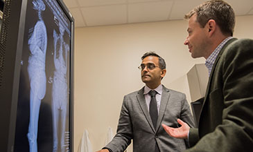 Northwestern Medicine doctors Tyler Koski and Alpesh Patel reviewing a patient's orthopaedic scans.