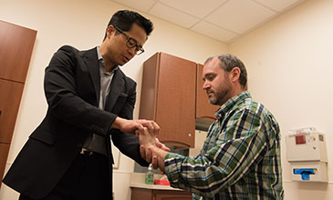 Northwestern Medicine physician Dr. Wellington Hsu examining a patient's hand injury.