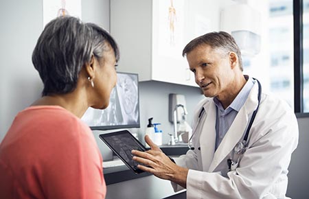 A physician consulting with a female patient about her joint replacement.
