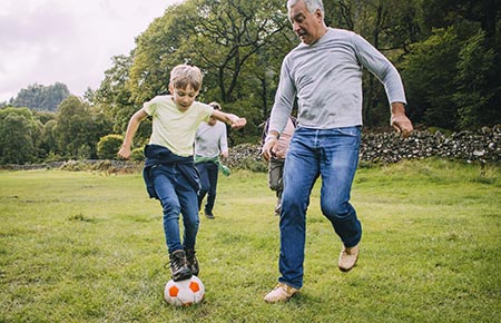 A man playing soccer with young children.