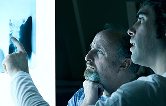 Doctors looking at spine X-ray