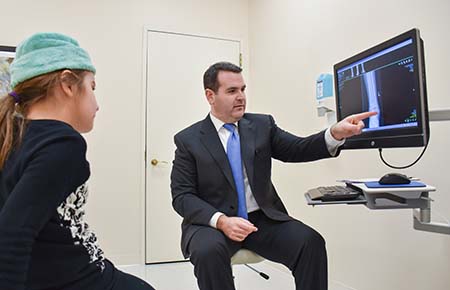 Northwestern Medicine Joint Replacement surgeon Dr. Benjamin Davis showing an X-ray to a patient.