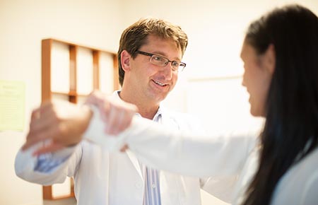 A Northwestern Memorial Hospital Joint Replacement Surgeon examining a patient's arm