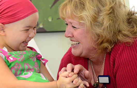 Cadence volunteer laughing with childhood cancer patient