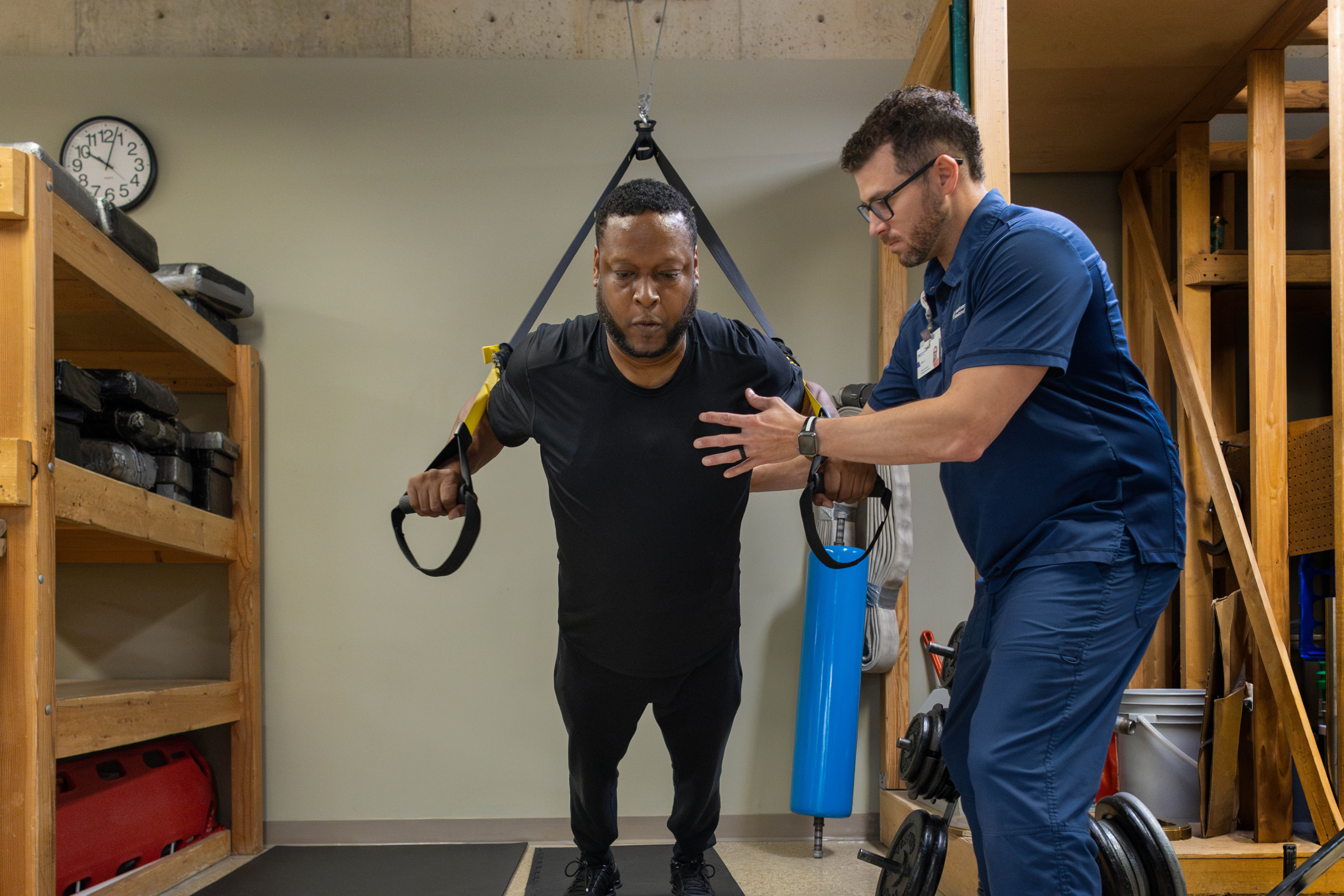 Patient using exercise equipment with the support of a physical therapist