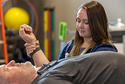 physical therapist supporting a patients arm while exercising