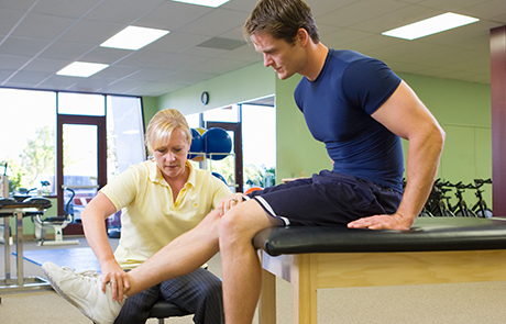 Physical therapist working on patient knee