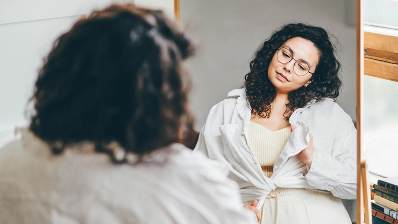 a woman looking in the mirror with her head tilted