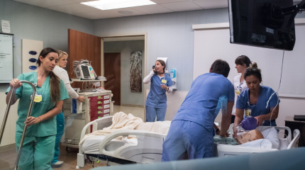 A team of medical professionals practicing a medical case in a simulation lab.