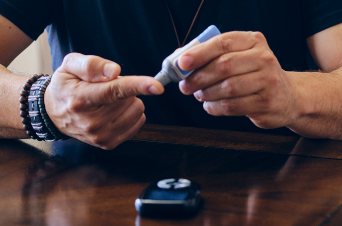 A person pricking their finger to take a glucose test.
