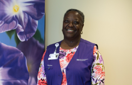 A woman smiling during her volunteer shift with Northwestern Medicine.