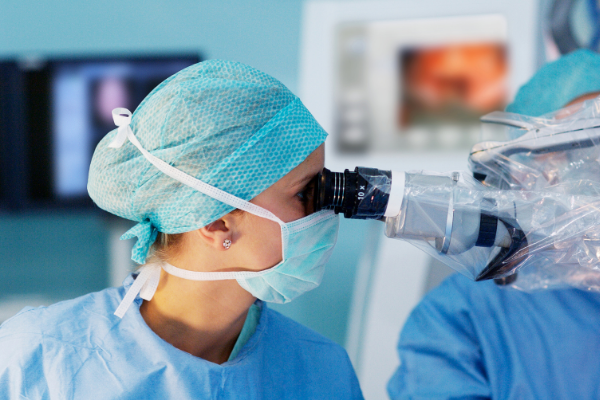 Researcher looking into a microscope