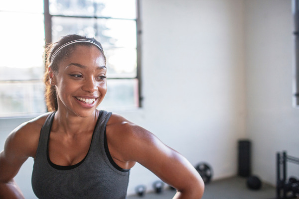 young, fit woman in the gym and she's smiling