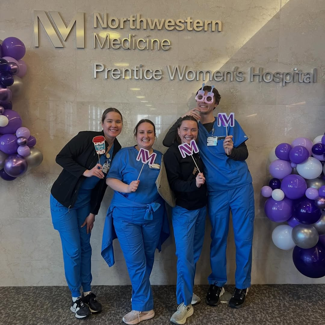 Hospital staff pose with Northwestern Medicine signs in the Prentice Women's Hospital.
