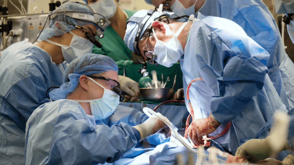 Surgeons in an operating room operating on a patient.
