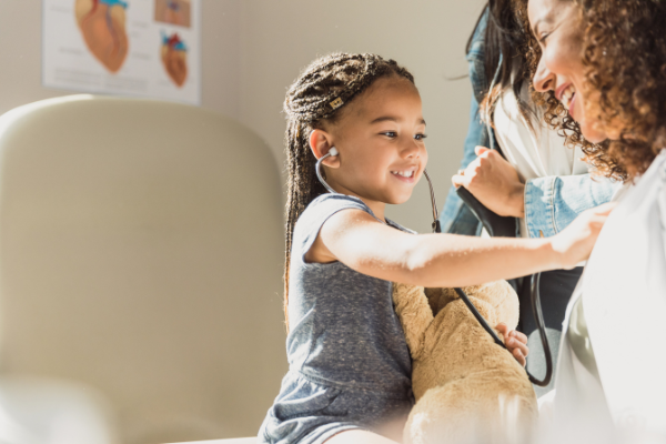 Young African American girl pretending to be a doctor