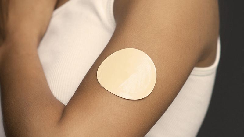 A nicotine patch on a person's upper arm.