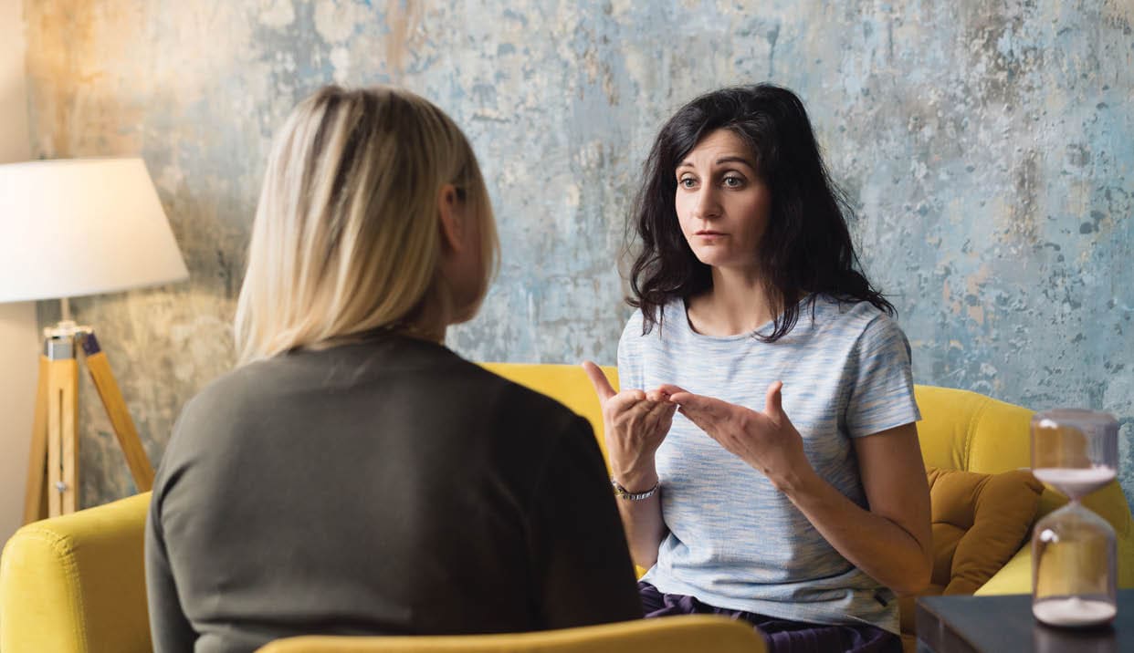 Woman psychologist talking to patient woman. Therapist's gestures. Female talking in coworking office