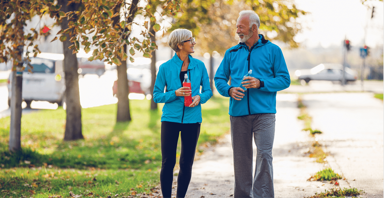 Senior couple walking together with water bottles.