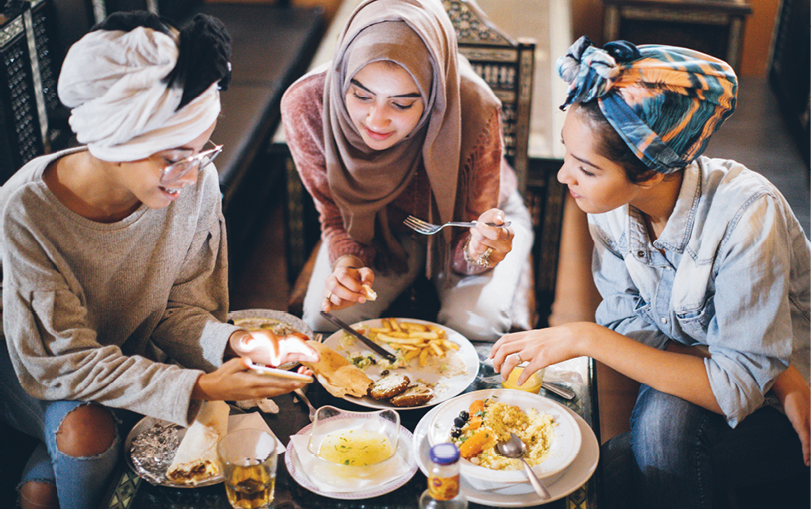Three north african teenage girl friends having lunch together in a typical restaurant 