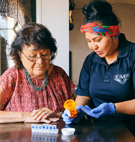 An Indigenous Navajo senior aged woman, receiving healthcare assistance in her home 