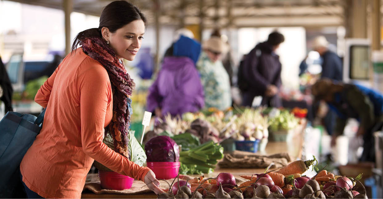 A woman shopping for produce at a farmers market 