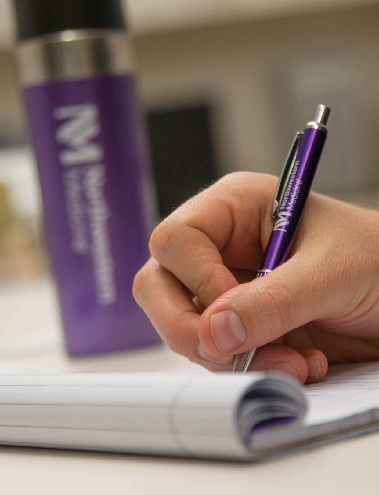Writing with our purple NM logo pen.