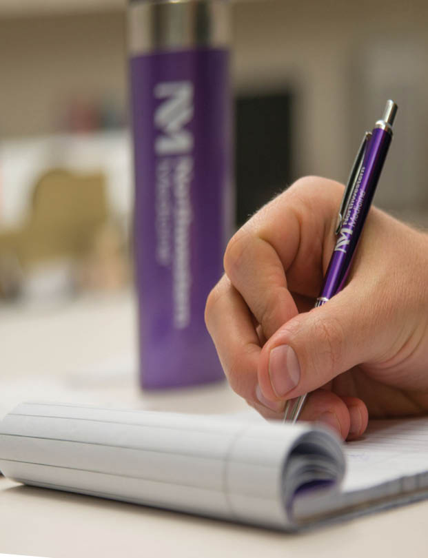 Writing with our purple NM logo pen.