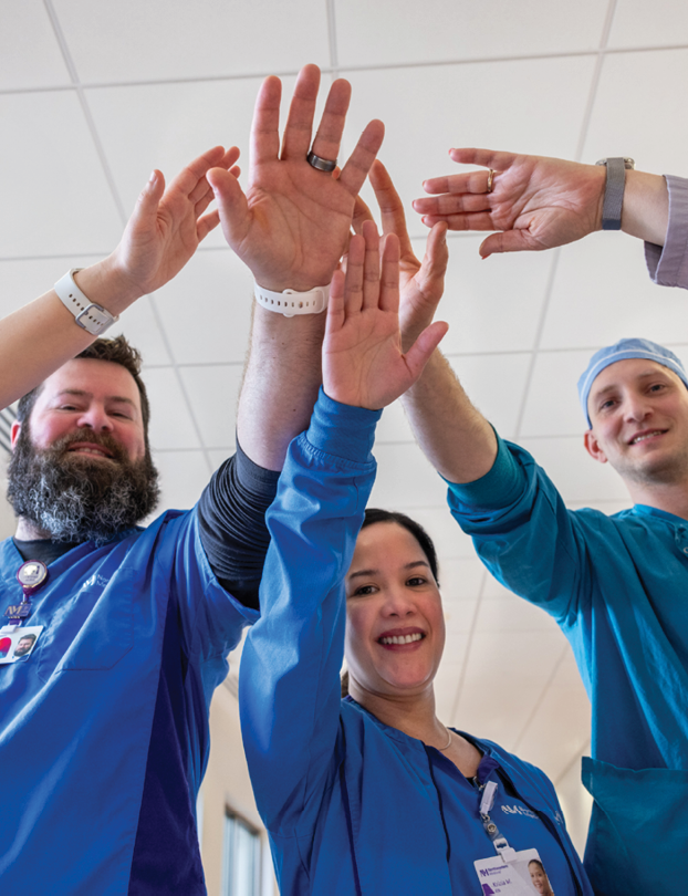 A group of people wearing blue shirts and holding hands. Description generated by AI