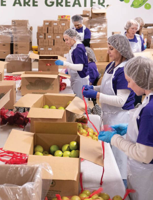 A group of people wearing gloves and working in a warehouse. Description generated by AI