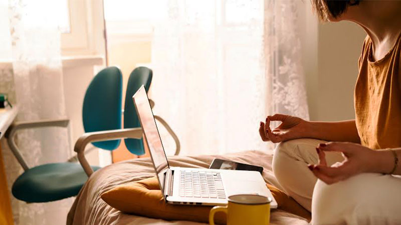 middle-aged woman meditates with laptop