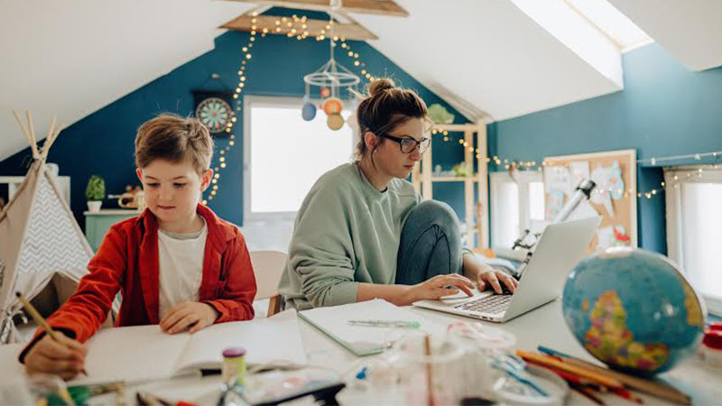 boy draws while mom works from home