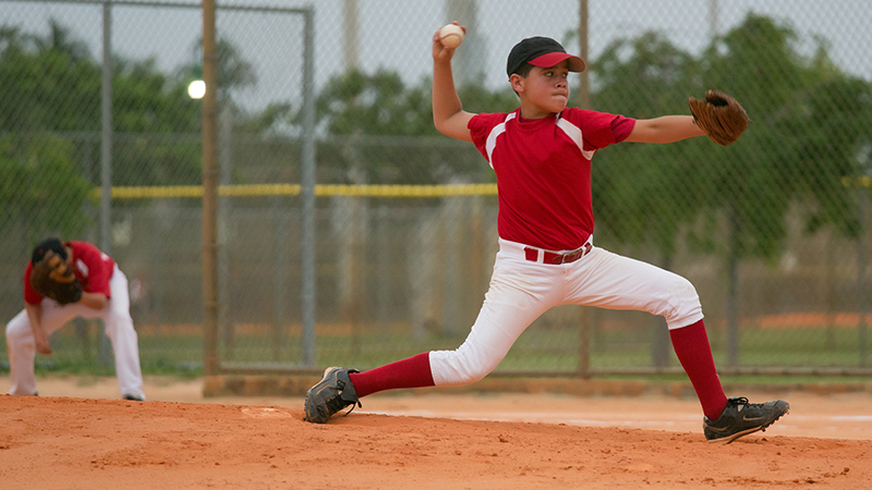 Young baseball player pitching a in a game. 