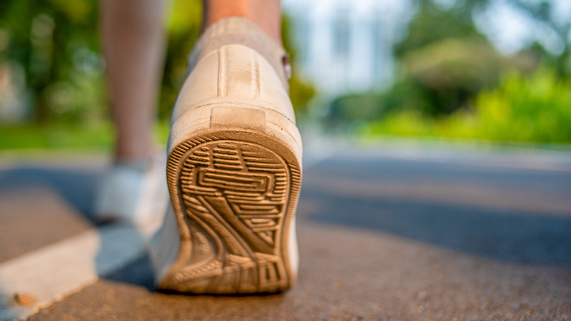 Bottom of a shoe walking on a road.