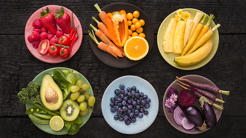 Six colorful plates with colorful fruits and vegetables, representing antioxidant-rich foods.
